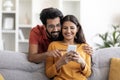 Shopping App. Happy Indian Couple Using Smartphone At Home Together Royalty Free Stock Photo