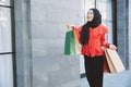 Shopping Arab Muslim adult woman in veil hijab clothes holding bags walk in city street enjoy happy smile Royalty Free Stock Photo