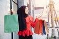 Shopping Arab Muslim adult woman in veil hijab clothes holding bags walk in city street enjoy happy smile Royalty Free Stock Photo