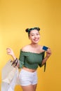 Shopping asian woman holds shopping bags and a credit card on ye Royalty Free Stock Photo