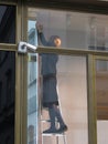 Shopping assistant preparing a store window display in Prague