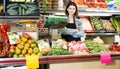 Shopping assistant weighing fruit and vegetables in grocery shop Royalty Free Stock Photo