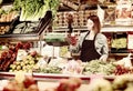 Shopping assistant weighing fruit and vegetables in grocery shop Royalty Free Stock Photo