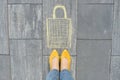 Shopping bag picture written on gray sidewalk in crayons with women legs in yellow shoes Royalty Free Stock Photo