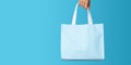 Shopping bag in woman\'s hand on blue background. Mockup design with blank space. Add text or logo. Generative Ai Royalty Free Stock Photo