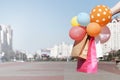 Shopping bags, colorful balloons in a woman`s hand Royalty Free Stock Photo