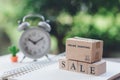 Shopping bags placed on wood word SALE with Vintage White Alarm Clock using as background shopping concept and delivery service Royalty Free Stock Photo