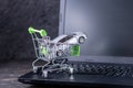 Shopping basket with car on laptop keyboard on dark background. Concept of online shopping vehicles on the Internet Royalty Free Stock Photo