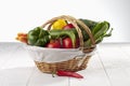 Shopping basket filled with various fresh organic vegetables on white wooden background Royalty Free Stock Photo