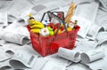 Shopping basket with foods on the pile of receipt. Consumerism and grocery expenses budget