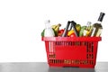 Shopping basket with grocery products on table against white background. Space for text Royalty Free Stock Photo