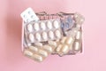 Shopping basket with medicinal pills and tablets closeup. Variety of pills, drugs, spray, syringe, suppositories in mini basket on