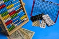 Shopping basket,pills in blister and abacus at classic blue background