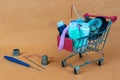 A shopping basket with threads and buttons. Next to thimbles and tools for sewing and embroidery. The background is made