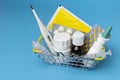 Shopping basket with various medicines purchased at the pharmacy on blue background
