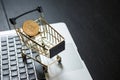 Shopping cart with bitcoin on laptop