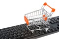 Shopping cart on black keyboard isolated on white