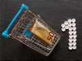 Shopping cart with cash money and number one made of pills, Concept care of your health is your priority. Top view