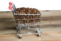 The shopping cart with coffee beans on wooden table Royalty Free Stock Photo