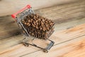 The shopping cart with coffee beans on wooden table Royalty Free Stock Photo