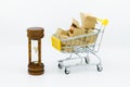 Shopping cart with coins inside box and hourglass for retail business. Image use for shopping, marketing place world wide,