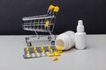 Shopping cart with compounded prescription medications shipped from a mail order pharmacy on a grey background