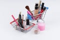 Shopping cart with cosmetics and moneys on white background