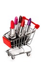 Shopping cart with a different lipsticks on white Royalty Free Stock Photo