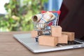 A shopping cart and express parcel full of Canadian dollar bills on a laptop keyboard