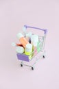 The shopping cart is filled with many round jars with multi-colored bright sparkles for nail polish