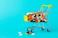 Shopping cart filled with pills. Blue background. Concept: full set of medicines in the store. Copy space for text Royalty Free Stock Photo