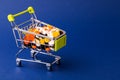 Shopping cart filled with pills. Blue background. Concept: full set of medicines in the store. Copy space for text Royalty Free Stock Photo