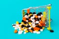 Shopping cart filled with pills. Blue background. Concept: full set of medicines in the store. Copy space for text Royalty Free Stock Photo