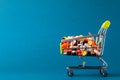 Shopping cart filled with pills. Blue background. Concept: full set of medicines in the store. Copy space for text Royalty Free Stock Photo