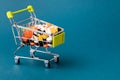 Shopping cart filled with pills. Blue background. Concept: full set of medicines in the store. Copy space for text Royalty Free Stock Photo