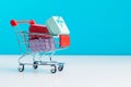 Shopping cart filled with presents isolated on blue background. Christmas, birthday and sale concept Royalty Free Stock Photo
