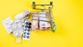 Shopping cart full of medicine with pills and capsules and euro banknotes. money . drug cost concept Royalty Free Stock Photo
