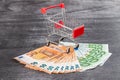 Shopping Cart Full of Cash. Shopping consept, euro money in cart. Shopping cart with euro banknotes on grey desk. Copy space Royalty Free Stock Photo