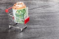 Shopping Cart Full of Cash. Shopping consept, euro money in cart. Shopping cart with euro banknotes on grey desk. Copy space Royalty Free Stock Photo