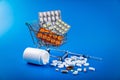 shopping cart full of drug and medicine pills on blue Royalty Free Stock Photo