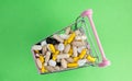 Shopping cart full of drug and medicine pills. pharmaceutical cost concept. medications in the cart. buying medicines. top view Royalty Free Stock Photo