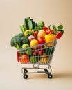Shopping cart full of healthy food fruits and vegetables isolated on beige background. Grocery and food store concept Royalty Free Stock Photo