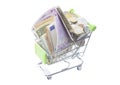 Shopping cart full of money banknotes and coins for shopping. Royalty Free Stock Photo