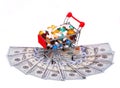 Shopping cart full with pills over dollar bills, isolated