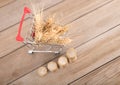 A shopping cart full of ripe wheat ears and a row of growing euro coins Royalty Free Stock Photo