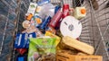 A shopping cart full of various different food products first person perspective supermarket shopping cart contents detail top