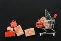 Shopping cart full of various gift boxes and a Christmas tree Royalty Free Stock Photo