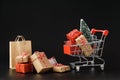 Shopping cart full of various gift boxes and a Christmas tree Royalty Free Stock Photo