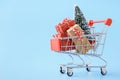 Shopping cart full of various gift boxes and a Christmas tree Royalty Free Stock Photo