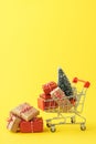 Shopping cart full of various gift boxes and a Christmas tree Royalty Free Stock Photo